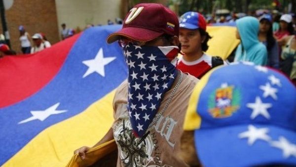 A Venezuelan opposition protester wearing a U.S. flag.