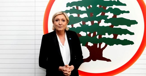 Marine Le Pen stands in front of the logo of the Christian Lebanese Forces party, Maarab, Lebanon Feb. 21, 2017.