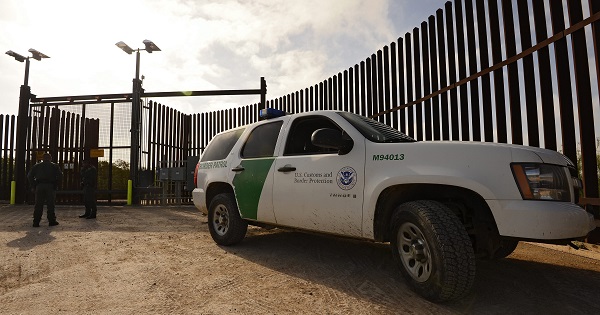 U.S. Border Patrol vehicles sit next to the border fence along the Rio Grande River near McAllen, Texas, March 19 2014.