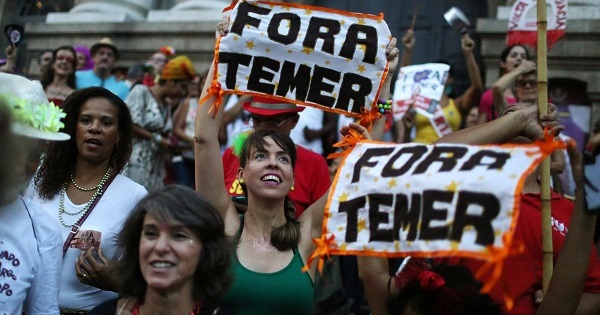 Brazilians protest with signs saying 
