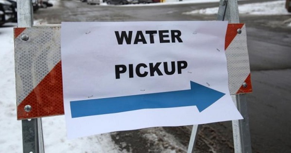 A ''Water Pickup'' sign points to a bottled water distribution center for Flint residents at a fire station in Flint, Michigan.