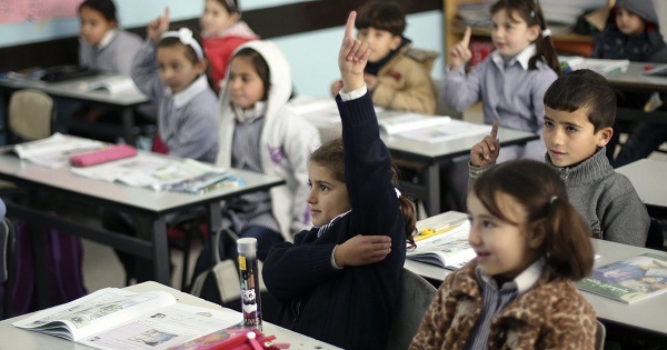 Palestinian first-graders sit with their schoolbooks during class in the West Bank city of Ramallah.