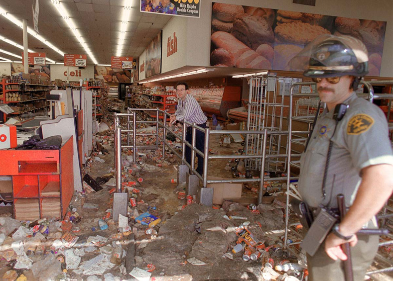April 30, 1992: A store owner and a Los Angeles Police Department (LAPD) officer look at the damage caused by looters in Los Angeles.