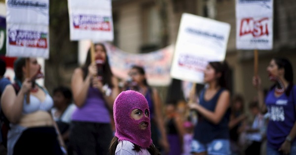 A girl wears a mask as women shout slogans during a demonstration to mark International Women's Day in Buenos Aires, Argentina, March 8, 2016.