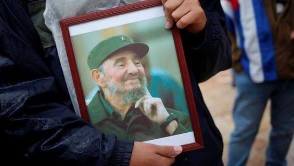 A supporter holds an image of former Cuban leader Fidel Castro at a tribute in Malaga, southern Spain, Dec. 4, 2016. 