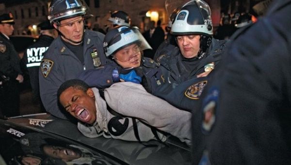 Cops arrest an activist peacefully protesting the police shooting of 16-year-old Kiki Gray in New York City, 2013.