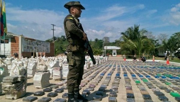 A Colombian police officer stands guard over eight tons of seized cocaine in Turbo, Antioquia department, on May 15, 2016