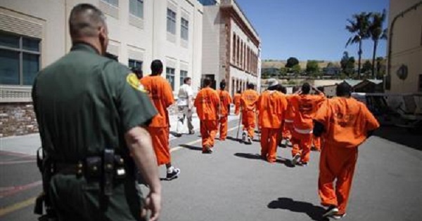 Inmates are escorted by a guard through San Quentin state prison in San Quentin, California.