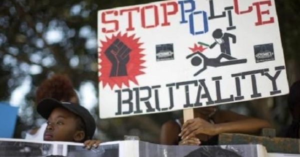 Activists hold signs during a silent protest against police brutality.