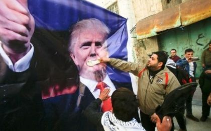 Palestinian demonstrators throw shoes on a poster depicting U.S. President Donald Trump during a protest in the West Bank city of Hebron, Feb. 24, 2017. 