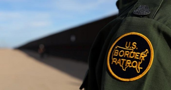 A U.S. border patrol agent walks along the border fence between Mexico and the United States near Calexico, California, U.S. Feb. 8, 2017.