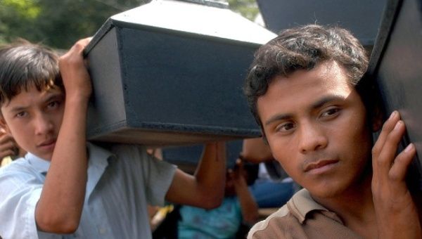 Coffins of victims of the El Mozote Massacre are carried, Dec. 13, 2003.