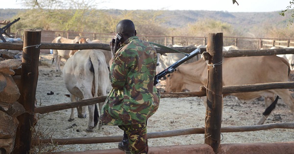 A Kenyan police officer talks on his mobile phone after he and his colleagues deployed to guard Sosian ranch.