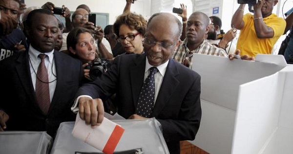 File photo from 2015 depicting Aristide dropping his ballot in an electoral bin at a polling station in Port-au-Prince.