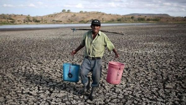 A farmer carries buckets of water in Palyitas town, Nicaragua, March 3, 2016.