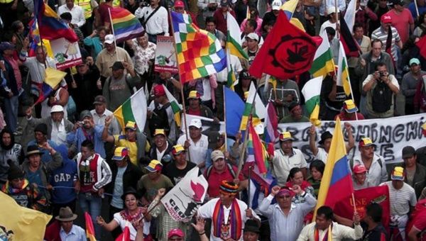 Protesters carry flags and banners while marching in Quito, Ecuador on August 12, 2015.