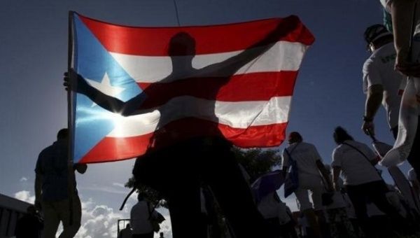 A protester holding a Puerto Rico's flag takes part in a march to improve health care benefits in San Juan, Puerto Rico, Nov. 5, 2015.