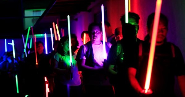Star Wars enthusiasts raise their lightsabers as they participate in the annual Earth Hour, Taguig city, Manila, Philippines Mar. 25, 2017.