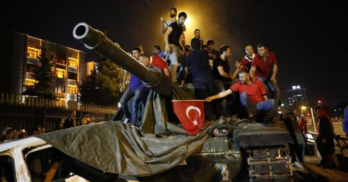 People stand on a Turkish Army tank in Ankara, Turkey, July 16, 2016.