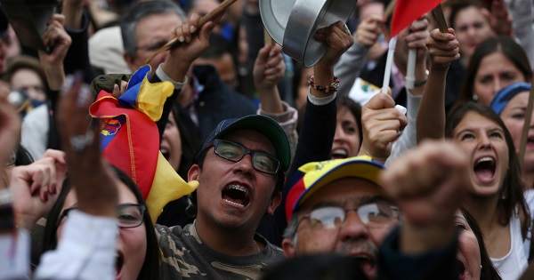 Supporters of presidential candidate Guillermo Lasso holding Ecuadorean flags protest outside the national electoral council headquarters in Quito.