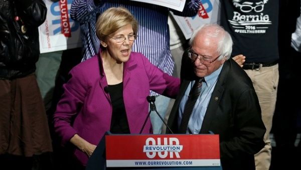 U.S. Senator Warren puts her arm around U.S. Senator Sanders after introducing him at a Our Revolution rally in Boston.