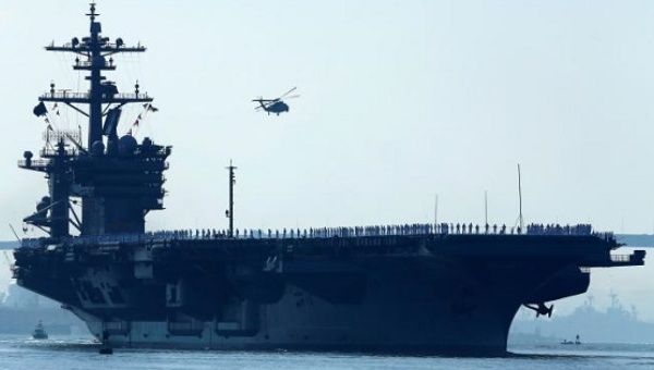 Sailors man the rails of the USS Carl Vinson, a Nimitz-class aircraft carrier, as it departs its home port in San Diego, California Aug. 22, 2014. 