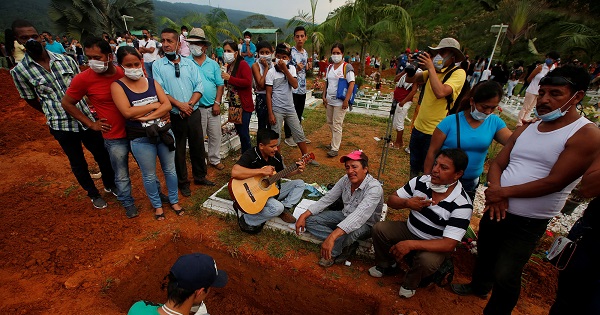 Family and friends mourn next to a grave in the cemetery mudslides caused by heavy rains leading several rivers to overflow, pushing rocks into buildings in Mocoa.