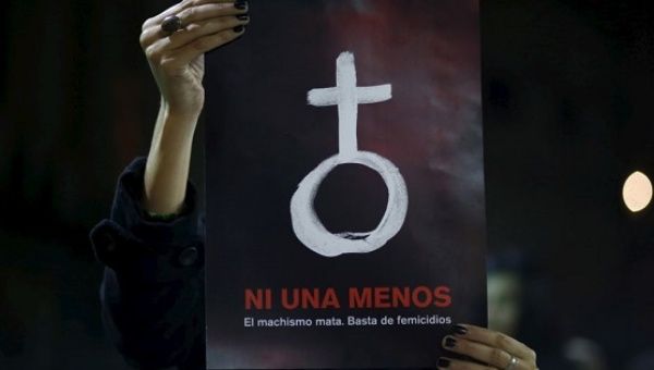 A woman holds up a poster with a female symbol during a demonstration demanding policies to prevent femicides in Buenos Aires, Argentina, June 3, 2015.