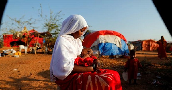 Zeinab, 14, sits as she holds her nephew at a camp for internally displaced people from drought-hit areas in Dollow, Somalia.