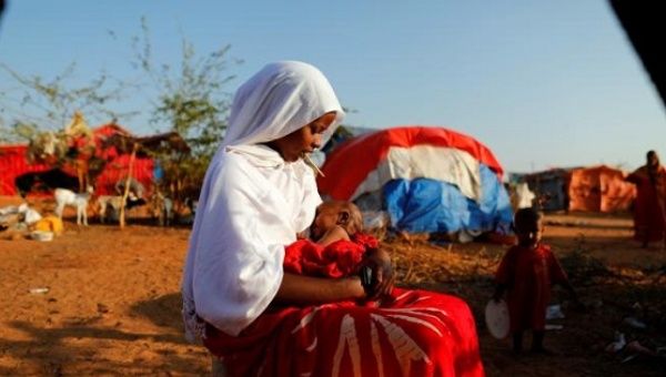 Zeinab, 14, sits as she holds her nephew at a camp for internally displaced people from drought-hit areas in Dollow, Somalia. 