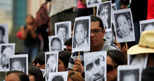 Journalists hold photographs of colleagues who have been killed in the last years while covering the news in Mexico, in Mexico City.