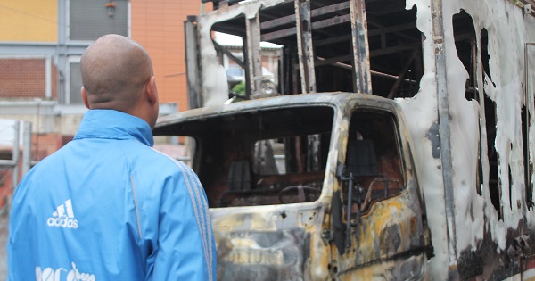 Hector Rodriguez, PSUV lawmaker, looks at a vehicle destroyed by vandals on Thursday night in Los Teques.