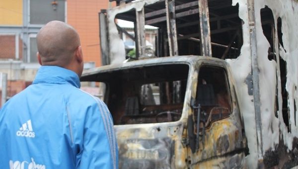 Hector Rodriguez, PSUV lawmaker, looks at a vehicle destroyed by vandals on Thursday night in Los Teques. 