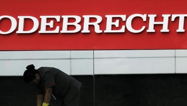 A worker cleans the corporate logo of the Odebrecht construction conglomerate at its headquarters in Sao Paulo, Brazil, April 17, 2017.