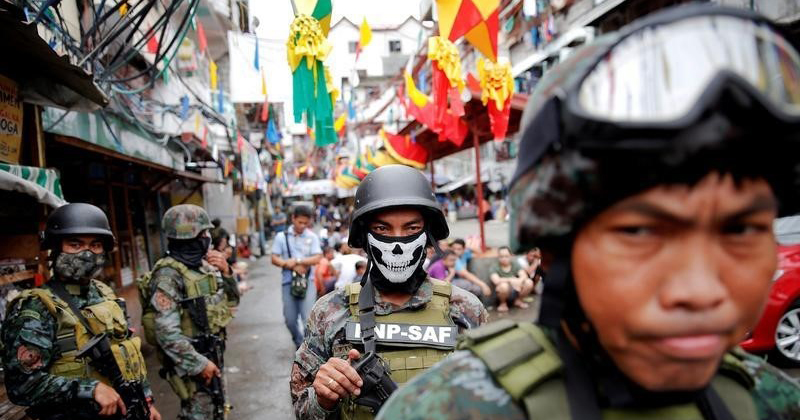 Armed security forces take a part in a drug raid, in Manila, Philippines, Oct. 7, 2016.