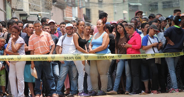 El Valle residents, in Caracas, stand in shock just outside a vandalised bakery.