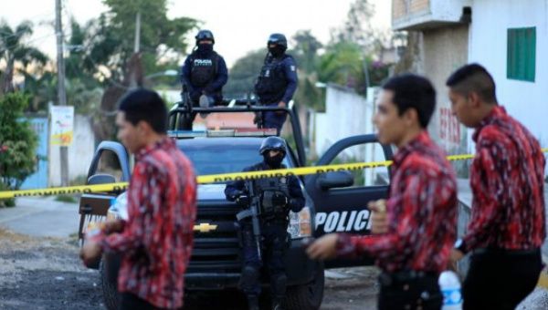 Police keep watch on the perimeter of a murder scene in Mexico.