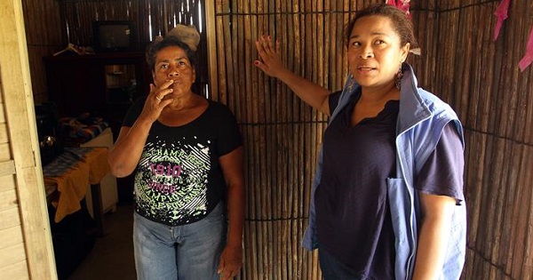 Neida Zambrano (L) and the head of the local United Nations project to adapt to climate change, Diana Diaz, give a tour of a new house adapted to climate change.