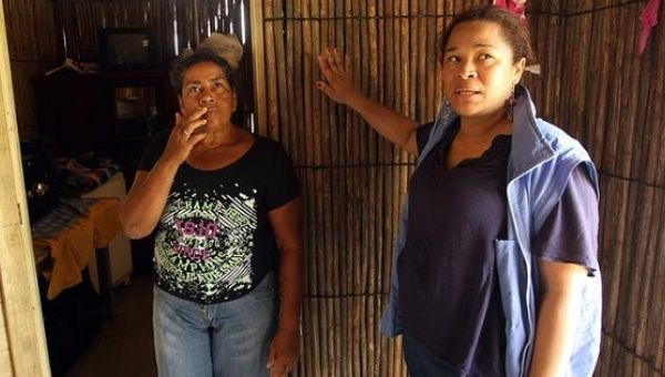 Neida Zambrano (L) and the head of the local United Nations project to adapt to climate change, Diana Diaz, give a tour of a new house adapted to climate change.