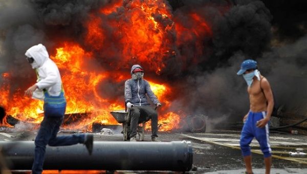 Opposition supporters set up burning street barricades during protests against the Maduro government in Caracas, April 24, 2017.