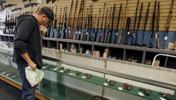 A customer looks over weapons for sale at the Pony Express Firearms shop in Parker.