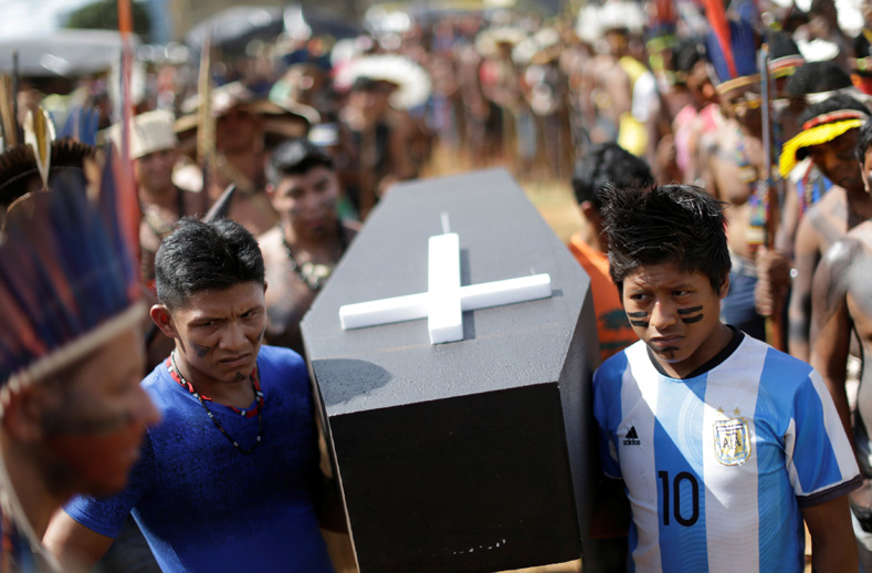 Brazilian Indigenous people carry a symbolic coffin, to show the death of Indigenous people's rights, as they take part in a demonstration against the violation of Indigenous people's rights, in Brasilia, Brazil, April 25, 2017. 