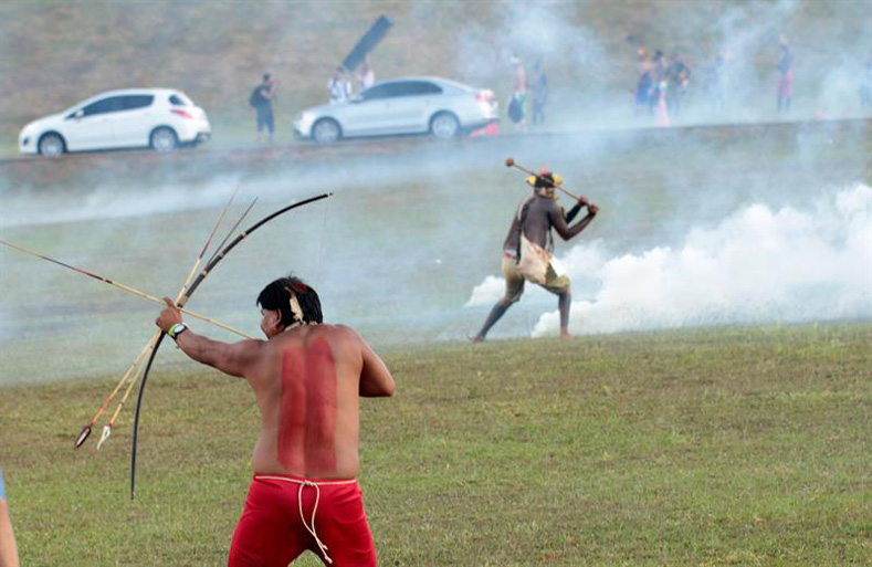 Brazilian Indigenous people fire arrows toward police who were attacking a demonstration against the violation of Indigenous people's rights, in Brasilia, Brazil, April 25, 2017.