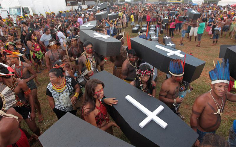 Brazilian Indigenous people carry a symbolic coffin, to show the death of Indigenous people's rights, as they take part in a demonstration against the violation of Indigenous people's rights, in Brasilia, Brazil, April 25, 2017. 