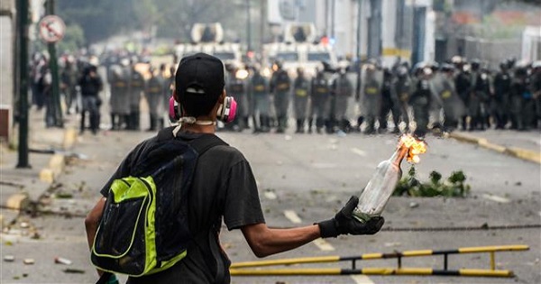 A Venezuelan opposition supporter holds a lit Molotov cocktail during clashes with riot police in Caracas on April 10, 2017.