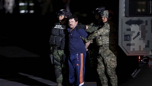 Recaptured drug lord Joaquin 'El Chapo' Guzman is escorted by soldiers in Mexico City, Jan. 8, 2016. 