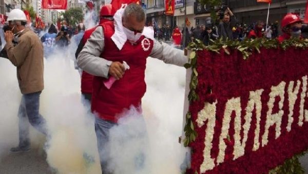 A protester reacts as police fires tear gas during a May Day demonstration in Istanbul May 1, 2014.