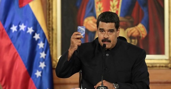 Venezuela's President Nicolas Maduro holds a copy of the Venezuelan Constitution as he speaks during a ceremony at Miraflores Palace in Caracas.