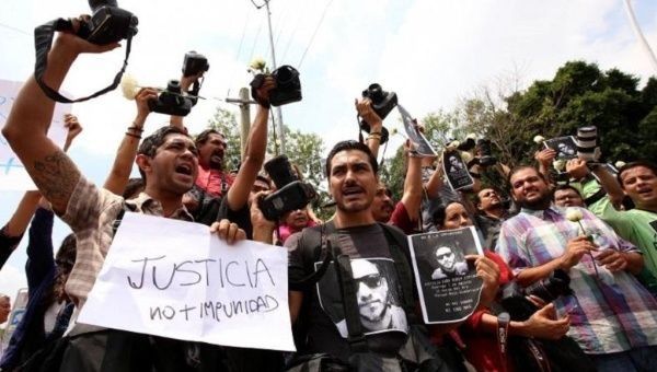 Activists in Mexico protest the murder of journalist Ruben Espinosa and demand justice, not impunity, in cases of violence against journalists.