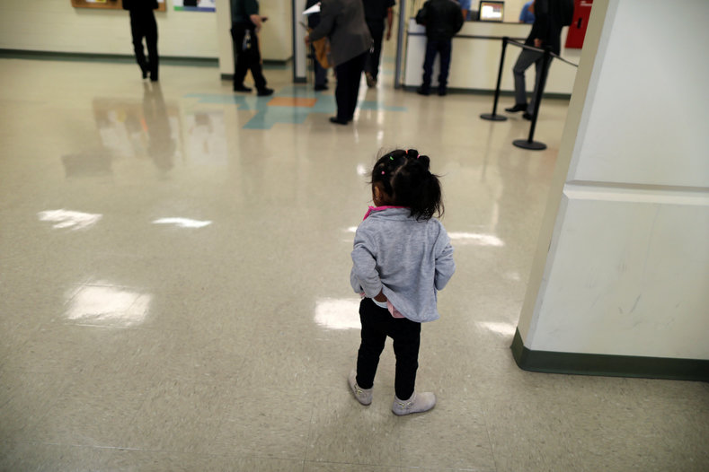 A girl waits with visitors in the lobby of the Adelanto immigration detention center.